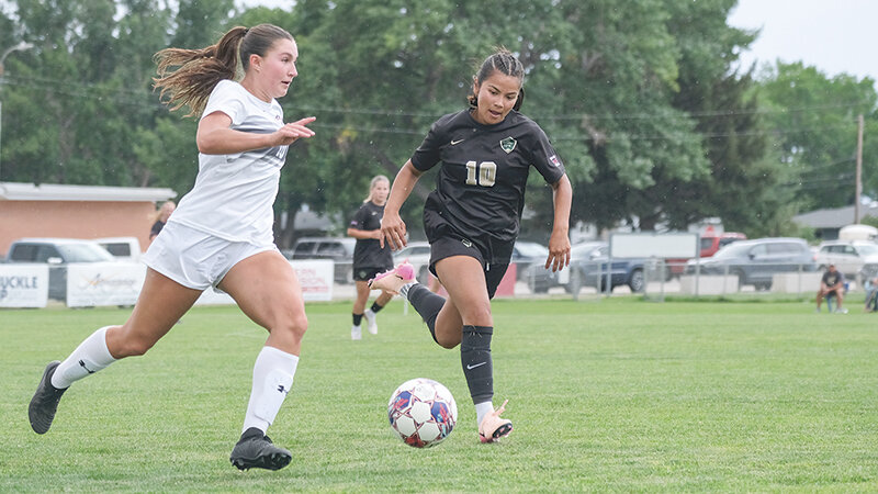 Elli Lewis (left) races down the sideline against a Rocky Mountain defender on Sunday. Lewis added the final touches to the Trappers 7-1 scrimmage win against the University of Providence on Friday.
Tribune photo by Seth Romsa